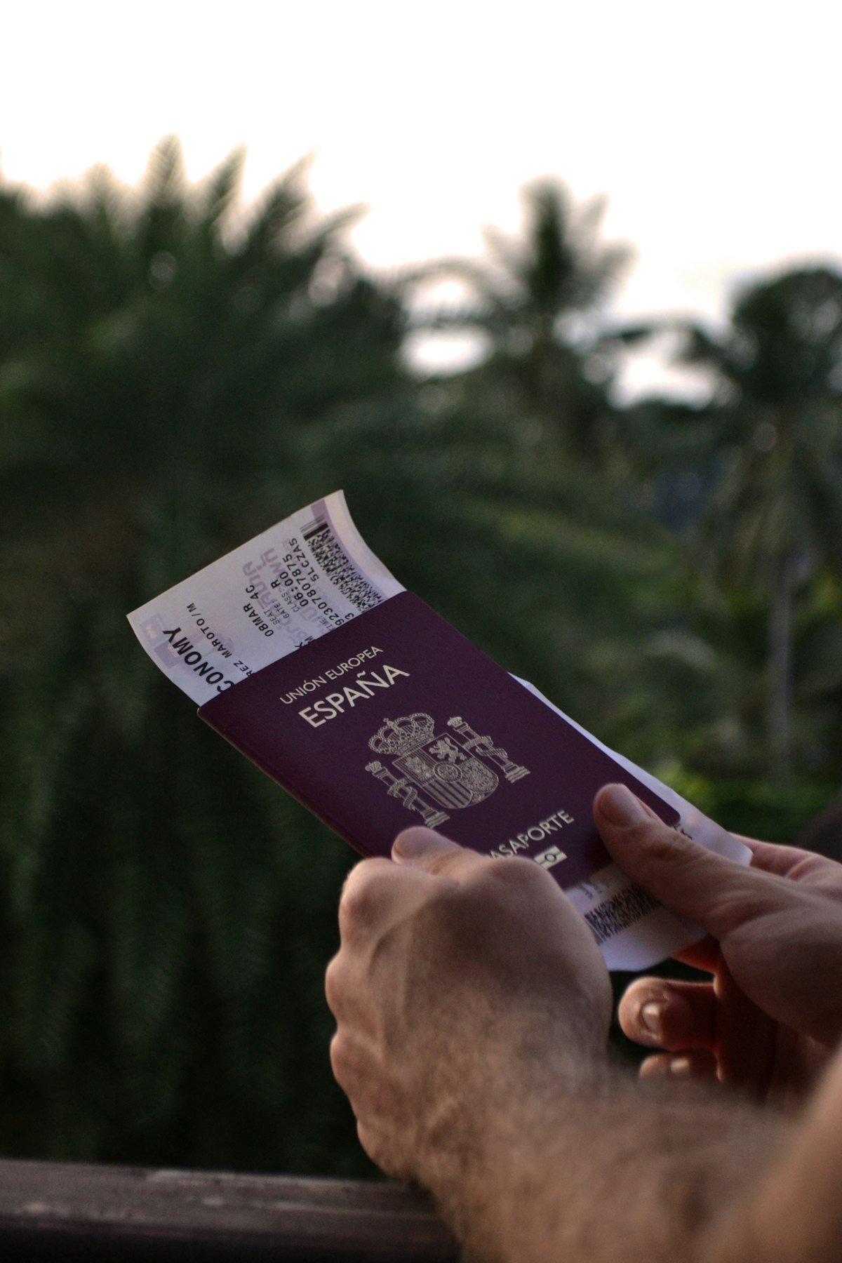 A traveller holding a passport and a boarding pass